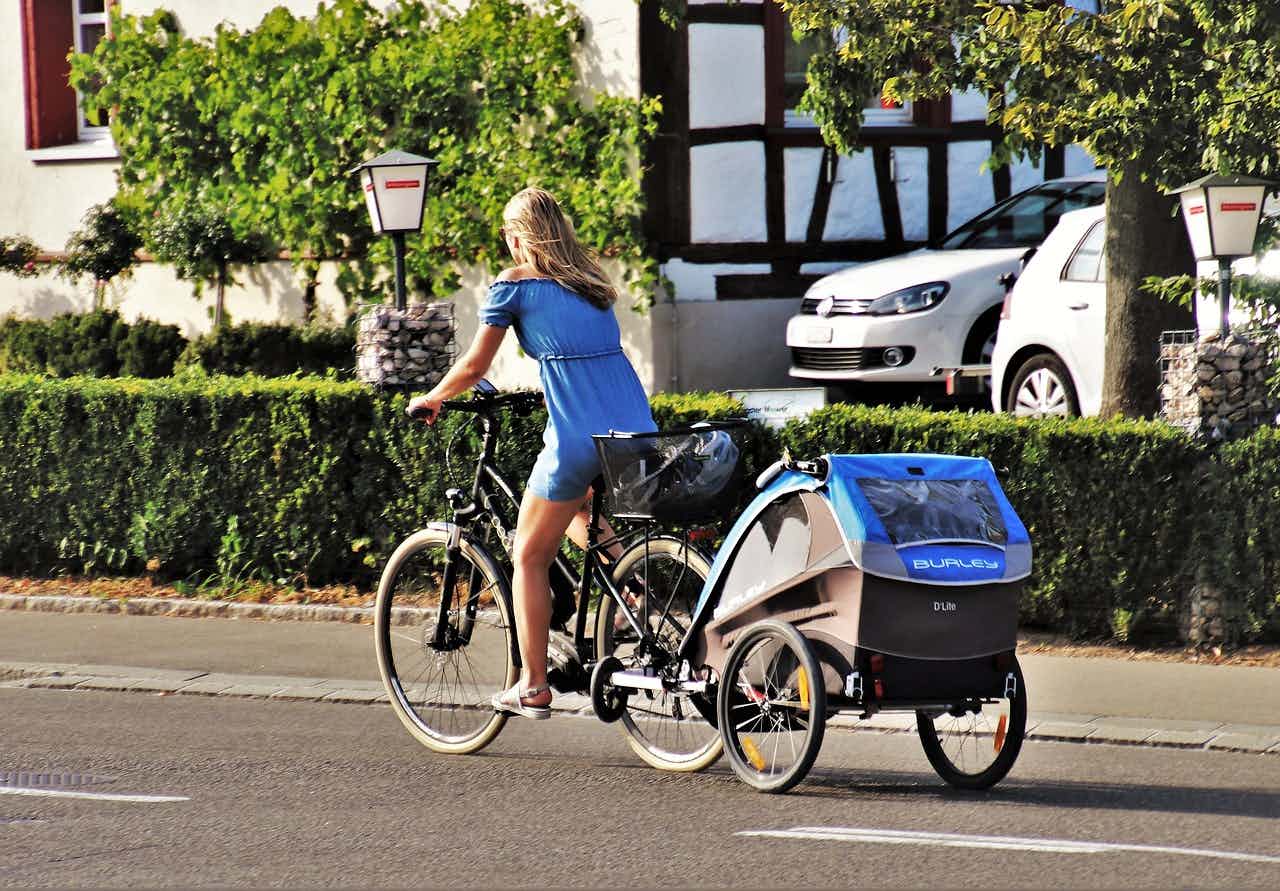 mamma cyklar med barn i vagn